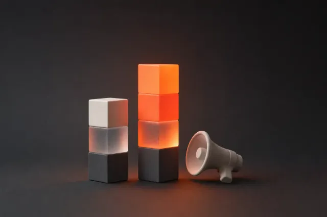 Twee stapels blokken als staafdiagram, de hoogste oranje verlicht, naast een megafoon