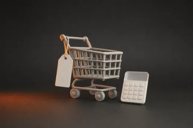 Een winkelwagentje met een leeg prijskaartje naast een rekenmachine
